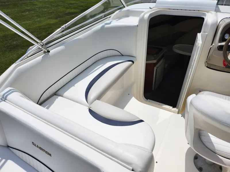 Slide: The Image of 2008 Glastron GT 249 boat interior with white seating and cabin entrance. - 11