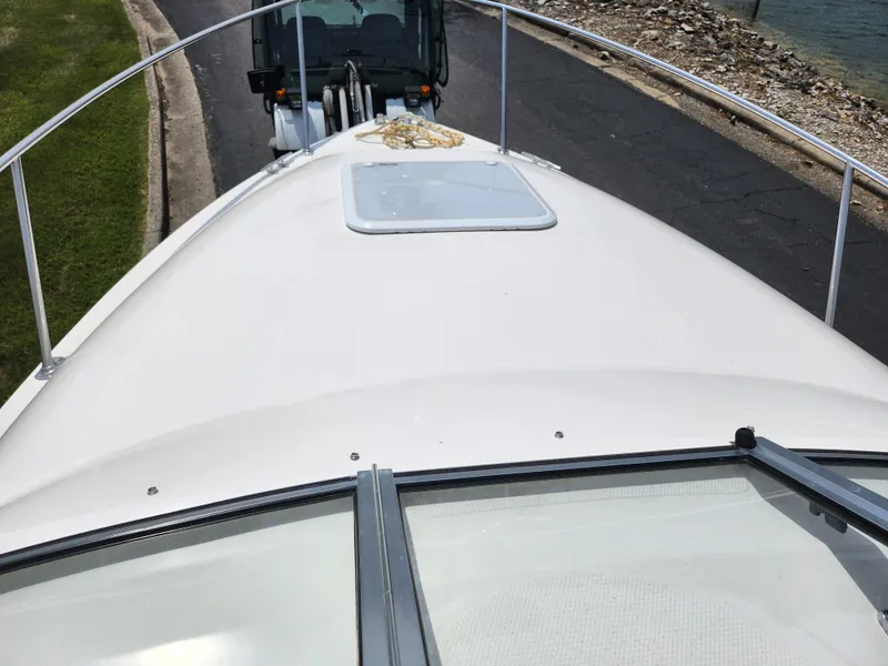 Slide: The Image of 2008 Glastron GT 249 boat on trailer, top deck view near water. - 14