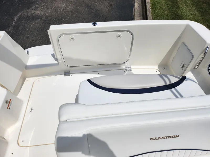 Slide: The Image of 2008 Glastron GT 249 boat interior, white seating and storage compartment. - 16
