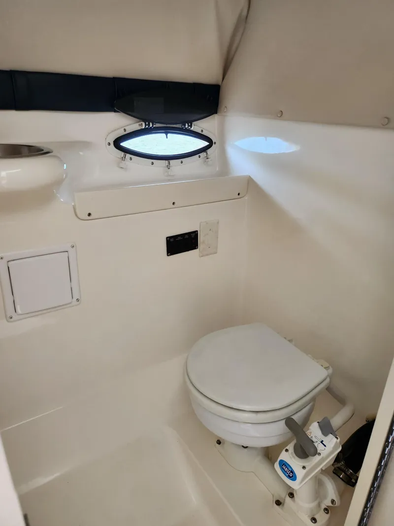 Slide: The Image of 2008 Glastron GT 249 boat bathroom with toilet and porthole window. - 23