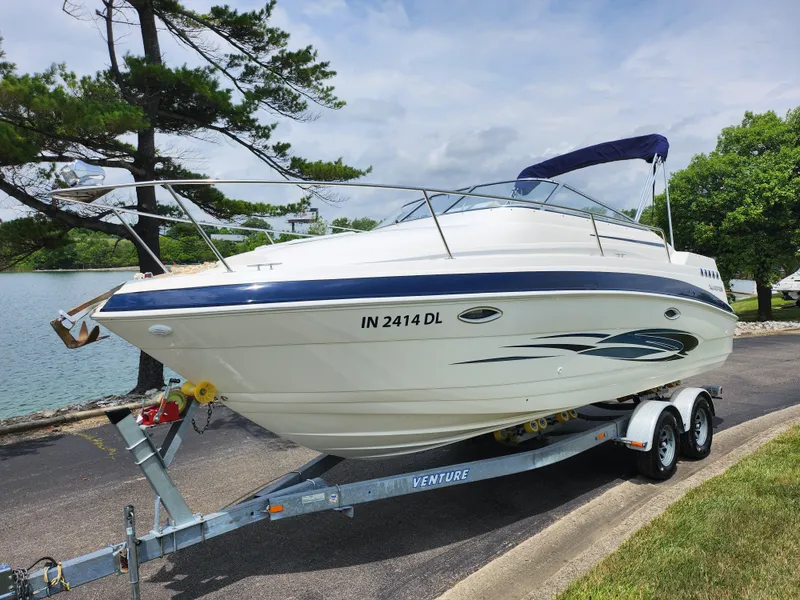 Slide: The Image of 2008 Glastron GT 249 boat on a trailer by a lakeside. - 8