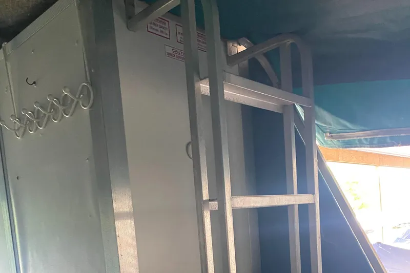 Slide: The Image of Interior of a 1994 Sun Tracker PARTY HUT 30 OB with metal ladder and storage. - 12