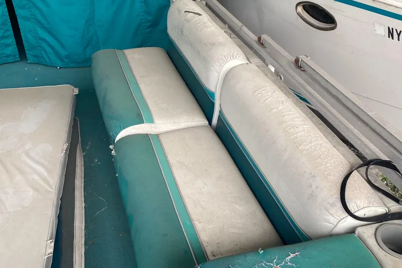 Slide: The Image of 1994 Sun Tracker PARTY HUT 30 OB interior seating area with teal and white cushions. - 3