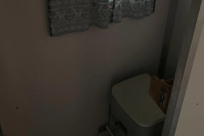 Slide: The Image of 1994 Sun Tracker PARTY HUT 30 OB boat bathroom with toilet and window curtain. - 8