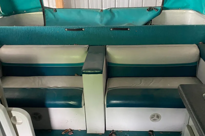 Slide: The Image of 1994 Sun Tracker PARTY HUT 30 OB interior seating area with teal and white upholstery. - 9