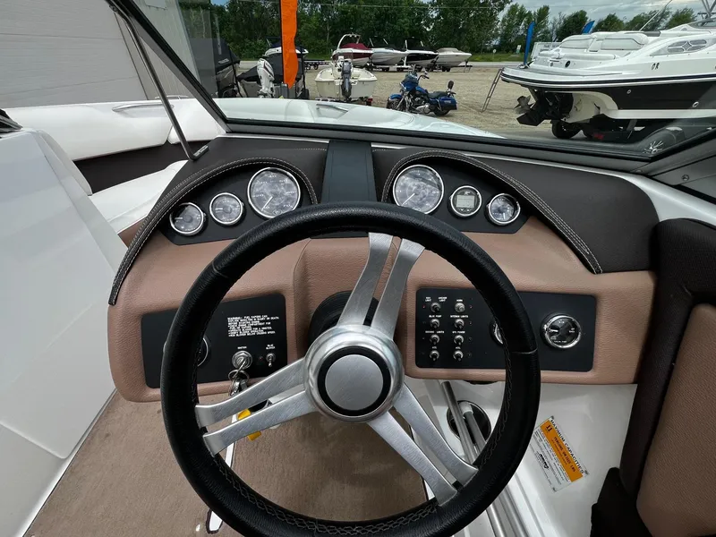 Slide: The Image of Steering wheel and dashboard of a 2011 Cobalt 200 boat, with gauges and controls. - 11