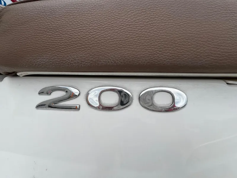 Slide: The Image of 2011 Cobalt 200 boat emblem on white surface with brown leather upholstery. - 3
