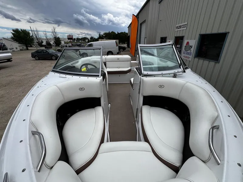 Slide: The Image of 2011 Cobalt 200 boat with white interior seating, parked outside a building. - 6