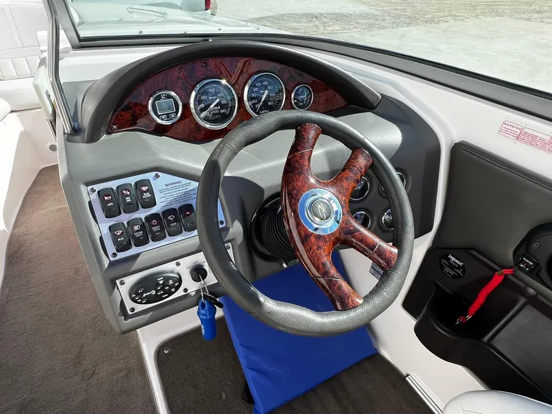 Slide: The Image of 2004 Regal 2200 Bowrider dashboard with woodgrain steering wheel and control panel. - 12