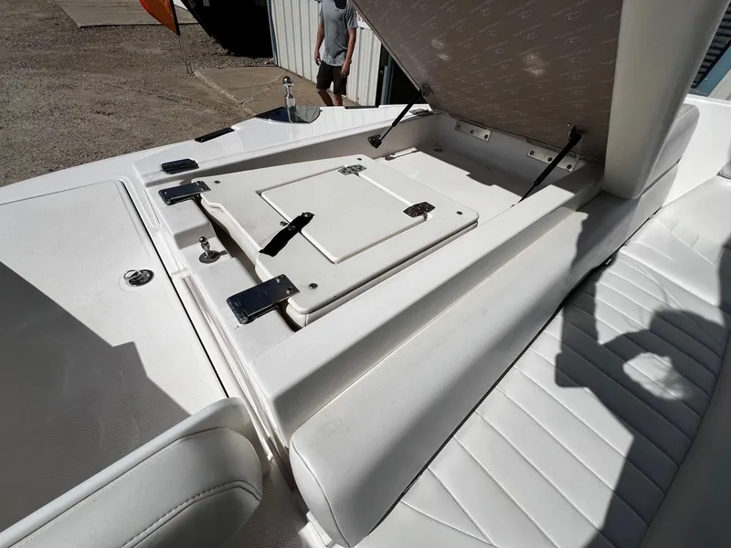 Slide: The Image of 2004 Regal 2200 Bowrider boat with open storage compartment and white seating. - 18