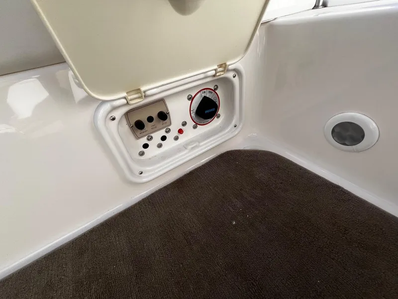 Slide: The Image of Control panel of a 2004 Regal 2200 Bowrider boat with carpeted flooring. - 19