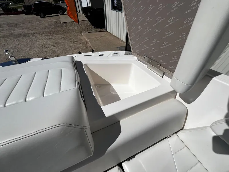 Slide: The Image of 2004 Regal 2200 Bowrider boat with white leather seating and storage compartment. - 25