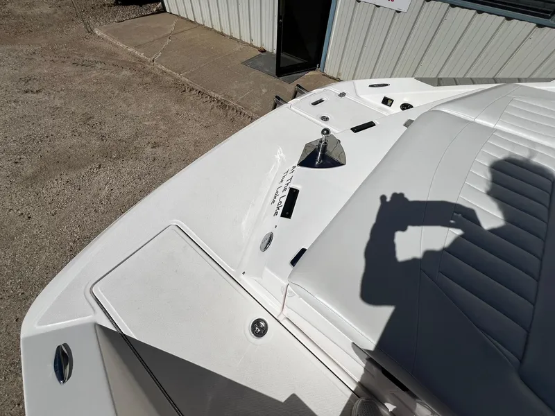 Slide: The Image of 2004 Regal 2200 Bowrider boat, white interior, docked near a building. - 26