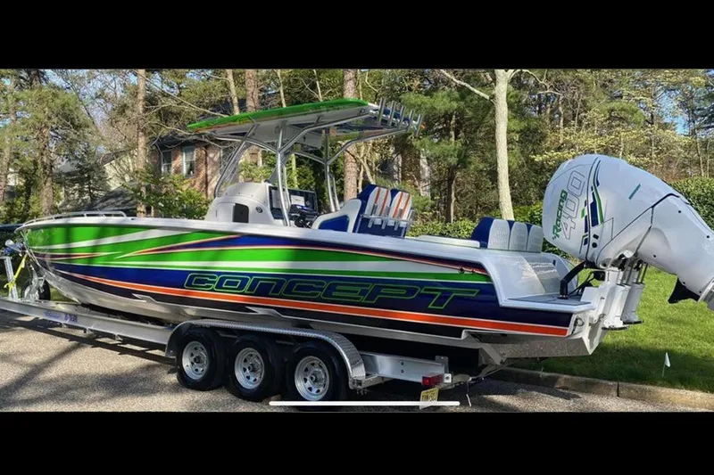 Slide: The Image of 2020 Concept 36' Cuddy Cabin boat with vibrant green, blue, and orange design on a trailer. - 2
