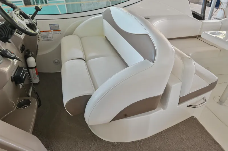 Slide: The Image of 2008 Cruisers Yachts 330 Express helm seat with white and beige upholstery. - 33