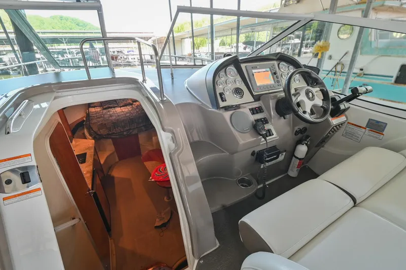 Slide: The Image of 2008 Cruisers Yachts 330 Express cockpit and cabin entrance with helm controls. - 34