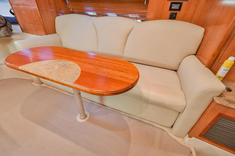 Slide: The Image of 2008 Cruisers Yachts 330 Express interior with beige sofa and wooden table. - 42