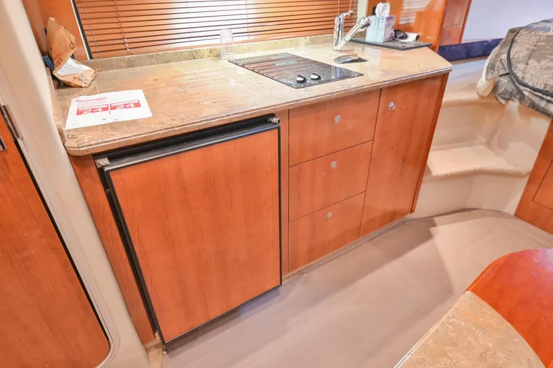 Slide: The Image of 2008 Cruisers Yachts 330 Express galley with wood cabinetry, mini-fridge, and stovetop. - 46