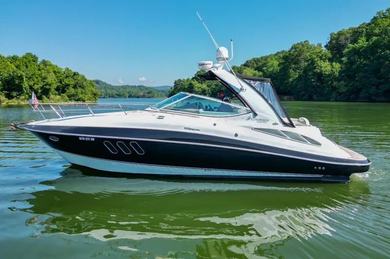 Slide: The Image of 2008 Cruisers Yachts 330 Express on a serene lake with lush green surroundings. - 7