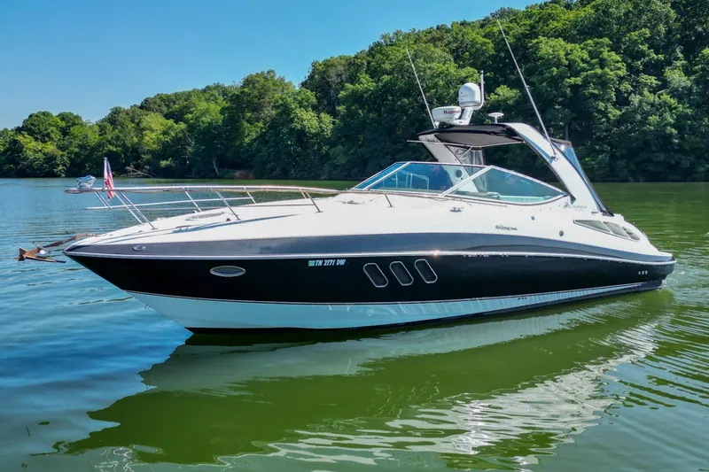 Slide: The Image of 2008 Cruisers Yachts 330 Express on a serene lake with lush green trees. - 8