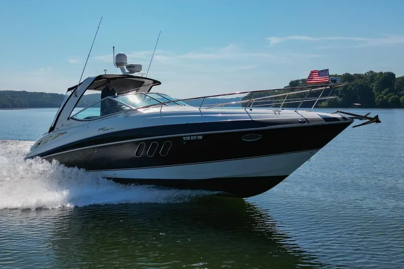 Slide: The Image of 2008 Cruisers Yachts 330 Express cruising on a lake with an American flag. - 2