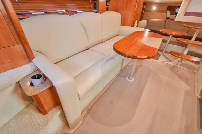 Slide: The Image of 2008 Cruisers Yachts 330 Express interior with beige sofa and wooden table. - 43
