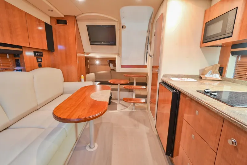 Slide: The Image of 2008 Cruisers Yachts 330 Express interior with kitchen, seating, and TV. - 49