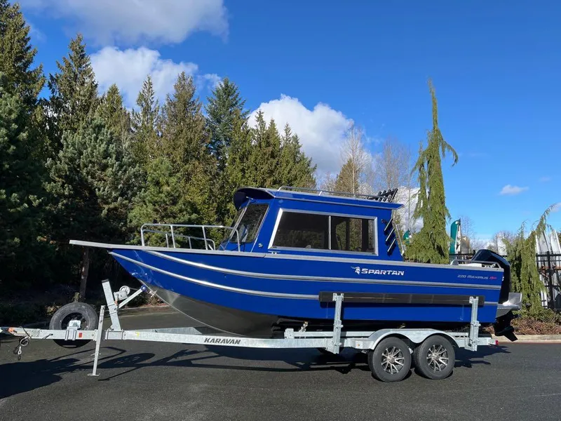 The Image of 2024 Spartan 220 Maximus boat on trailer, blue exterior, parked outdoors. - 0
