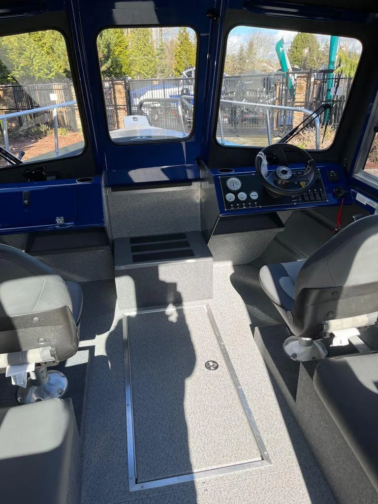 Slide: The Image of 2024 Spartan 220 Maximus boat interior with steering console and seating. - 2