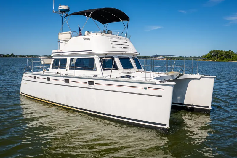 Slide: The Image of 2002 PDQ Power Catamaran MV/34 Passagemaker on calm waters under clear blue sky. - 2