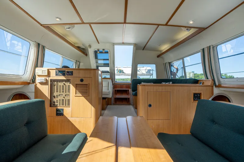 Slide: The Image of Interior of 2002 PDQ Power Catamaran MV/34 Passagemaker with wooden furnishings and green seating. - 23