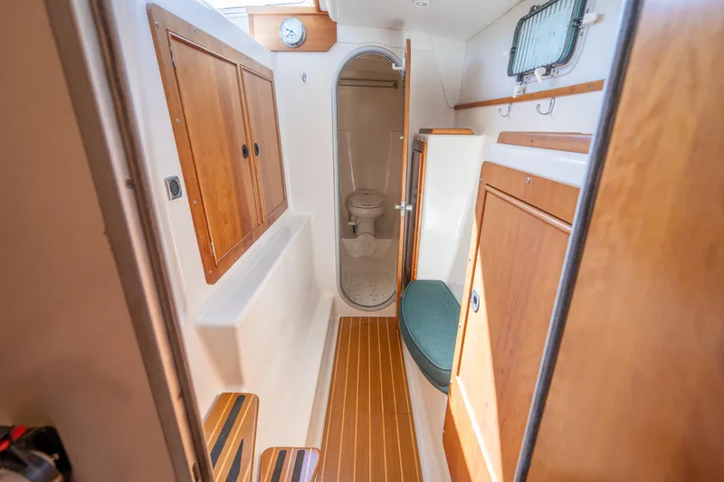 Slide: The Image of 2002 PDQ Power Catamaran MV/34 Passagemaker interior bathroom with wooden cabinets and toilet. - 27