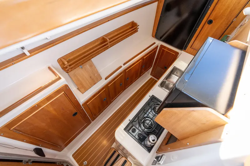 Slide: The Image of Interior kitchen of 2002 PDQ Power Catamaran MV/34 Passagemaker with wooden cabinets and stove. - 32