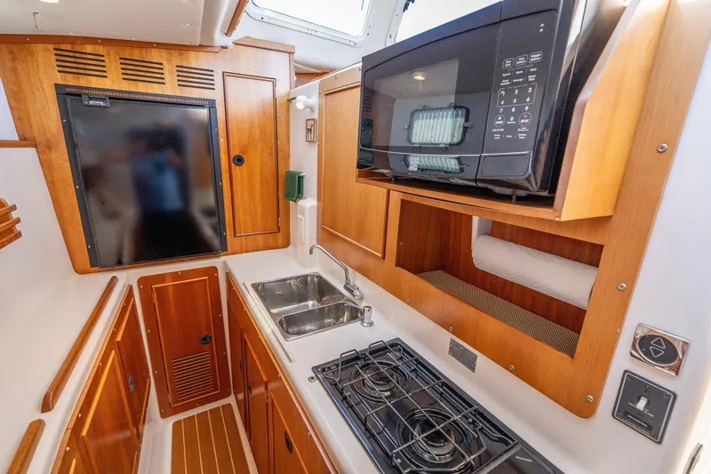 Slide: The Image of Compact kitchen area in 2002 PDQ Power Catamaran MV/34 Passagemaker with stove, sink, and microwave. - 34