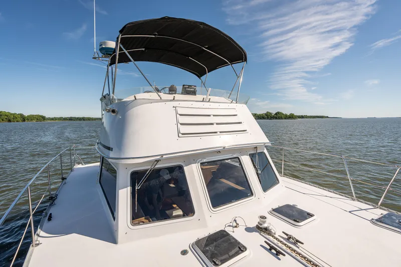 Slide: The Image of 2002 PDQ Power Catamaran MV/34 Passagemaker on calm waters under a clear blue sky. - 48