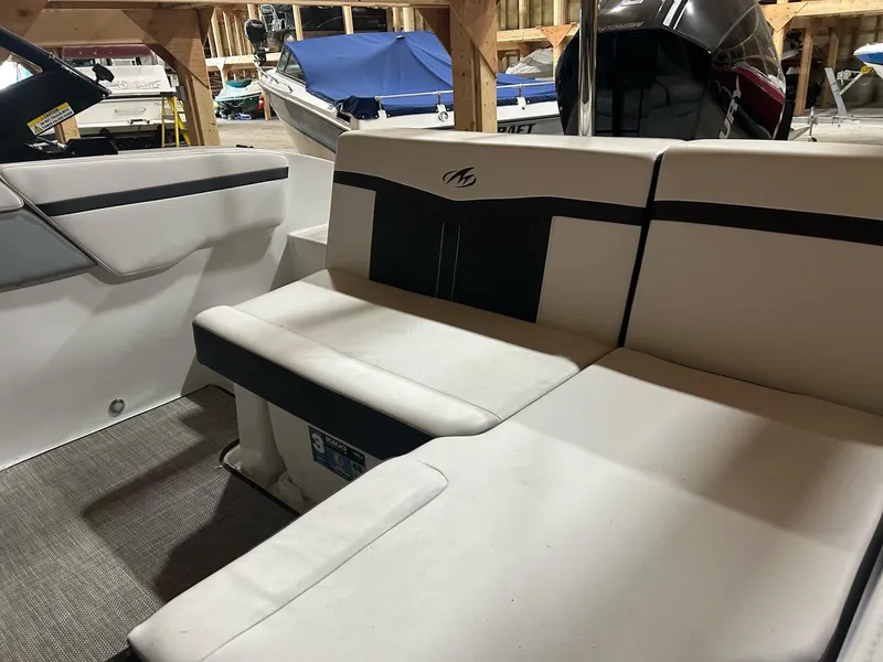 Slide: The Image of 2022 Monterey M-225 boat interior with white and black seating in storage. - 3