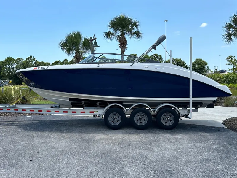 The Image of 2022 Yamaha Boats SX250 on a trailer, parked outdoors with palm trees in the background. - 0