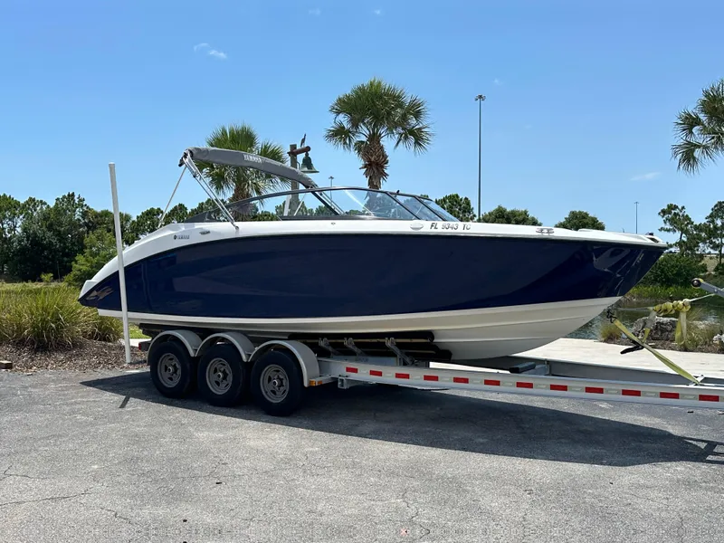 Slide: The Image of 2022 Yamaha Boats SX250 on a trailer, parked outdoors. - 1