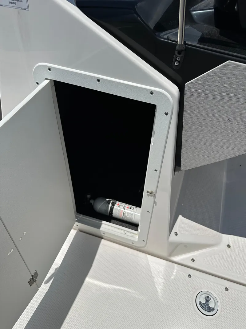 Slide: The Image of 2022 Yamaha Boats SX250 storage compartment with fire extinguisher. - 10