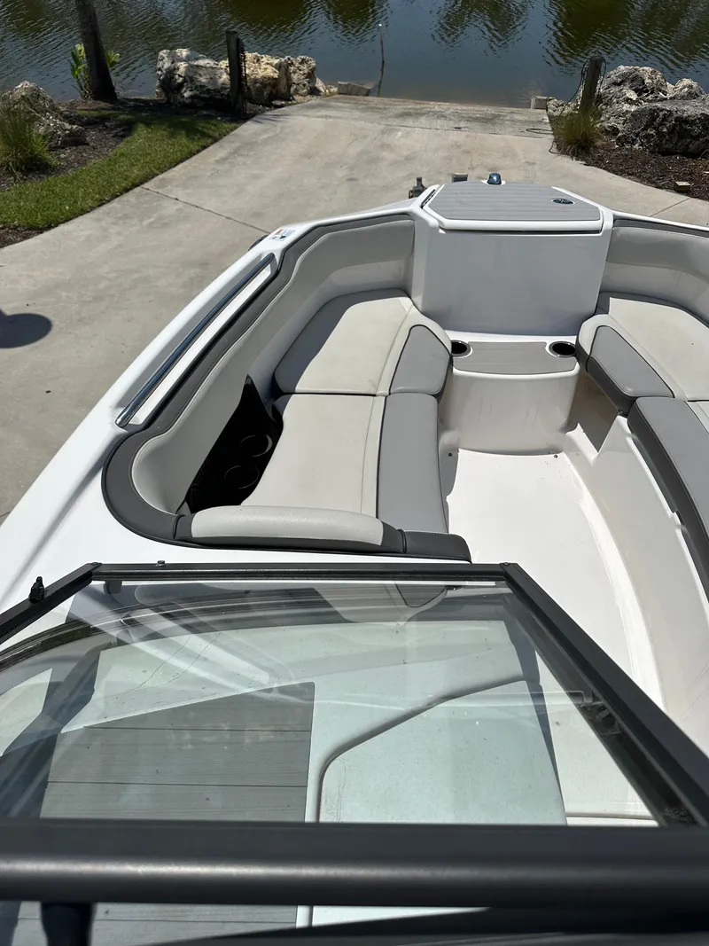 Slide: The Image of 2022 Yamaha Boats SX250 bow seating area near water. - 26