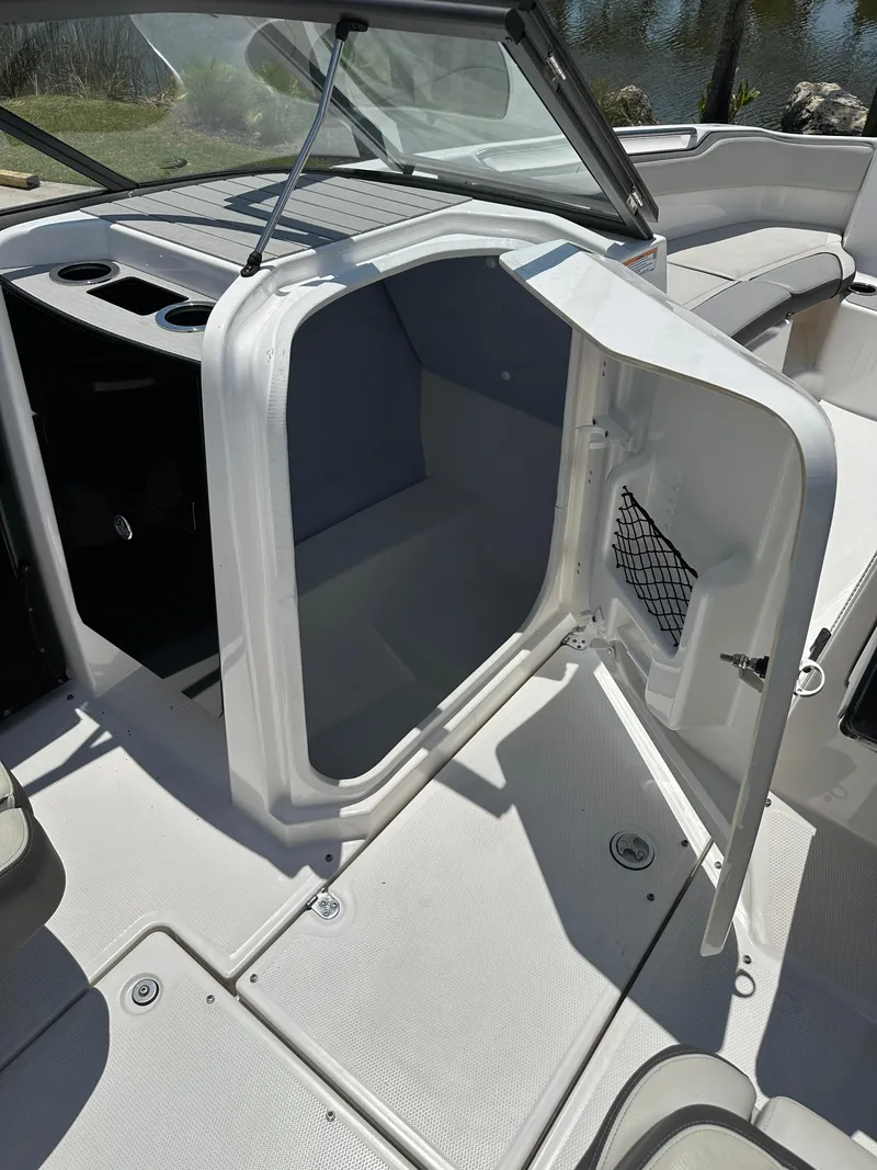 Slide: The Image of 2022 Yamaha Boats SX250 interior storage compartment with open door. - 8