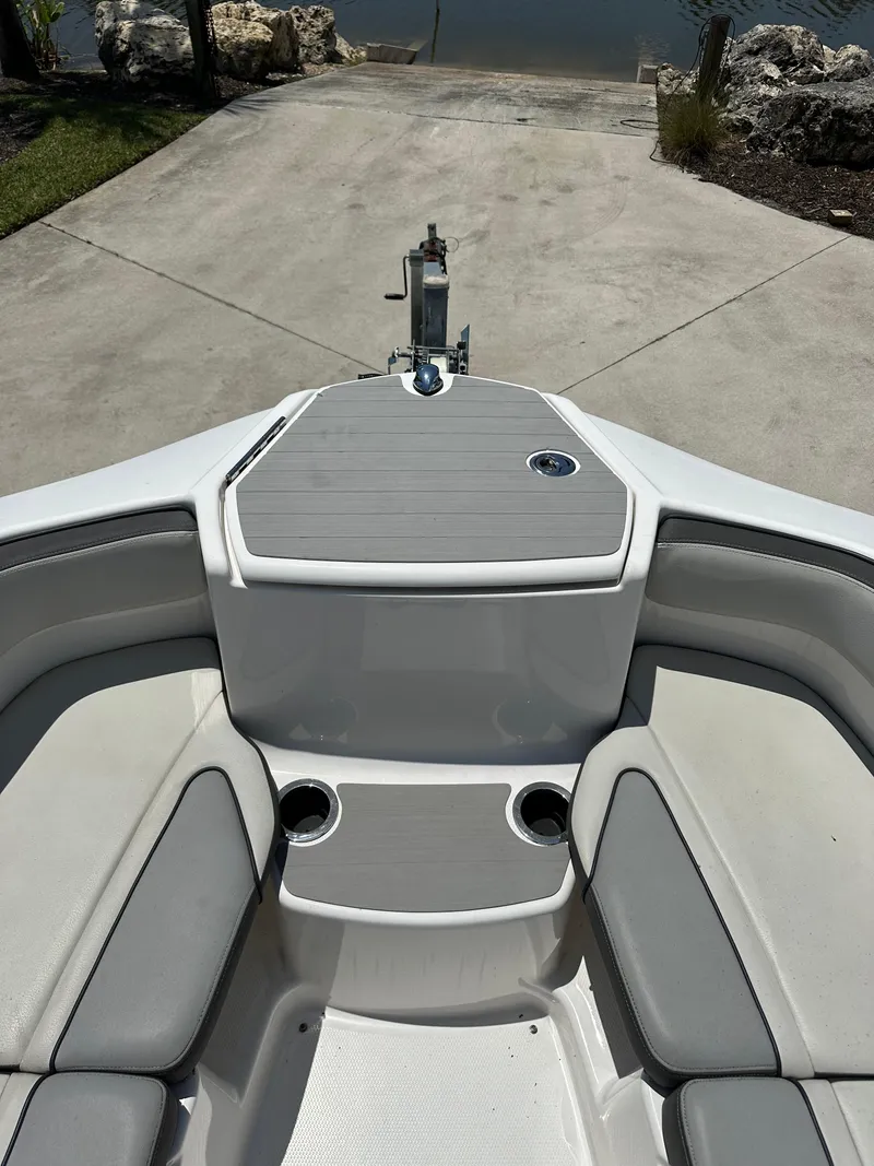 Slide: The Image of 2022 Yamaha Boats SX250 bow seating area with cup holders and storage. - 9