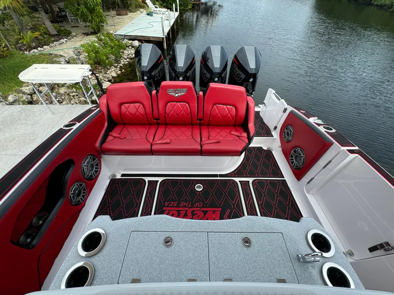 Slide: The Image of Luxury Deep Impact 399 boat interior with red seating, quad engines, and waterfront view. - 12