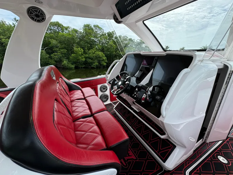 Slide: The Image of Luxury boat interior with red leather seats, modern dashboard, and scenic view. Deep Impact 399, 2022. - 17