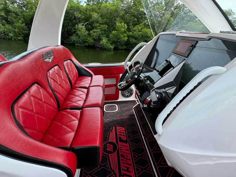 Slide: The Image of Luxurious 2022 Deep Impact 399 boat interior with red leather seats and modern dashboard. - 18