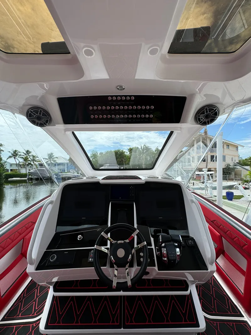 Slide: The Image of Luxury yacht cockpit with modern controls, Deep Impact 399, 2022 model, featuring sleek design and waterfront view. - 23