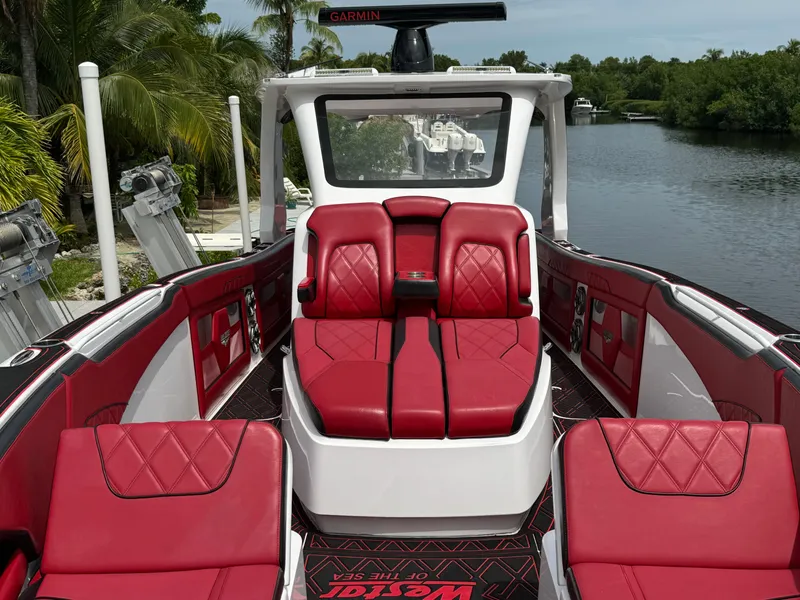 Slide: The Image of Luxurious 2022 Deep Impact 399 boat with red leather seating on a serene waterway. - 33