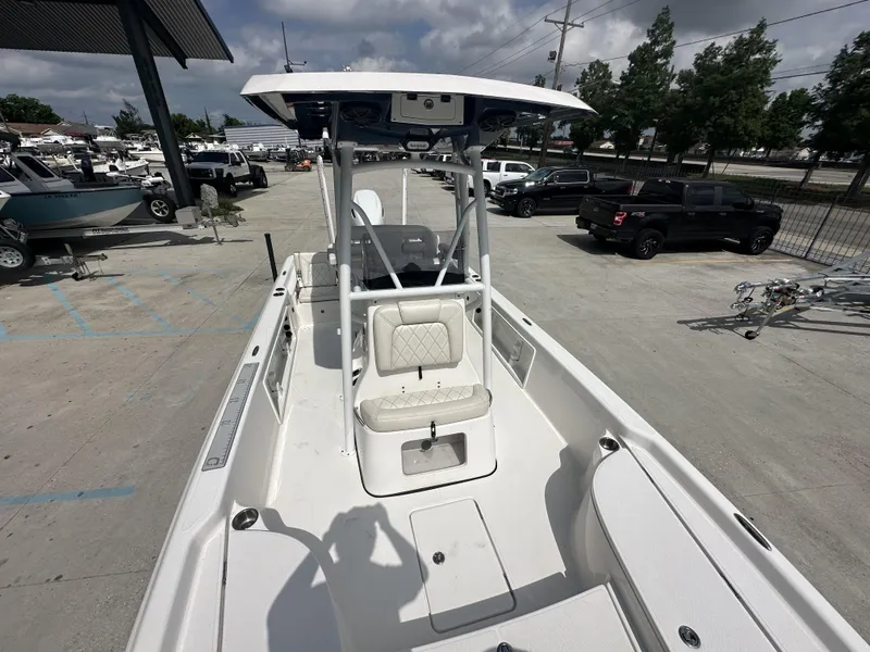 Slide: The Image of 2022 Blue Wave 2400 PURE BAY boat at a dealership, showcasing interior seating and console. - 10