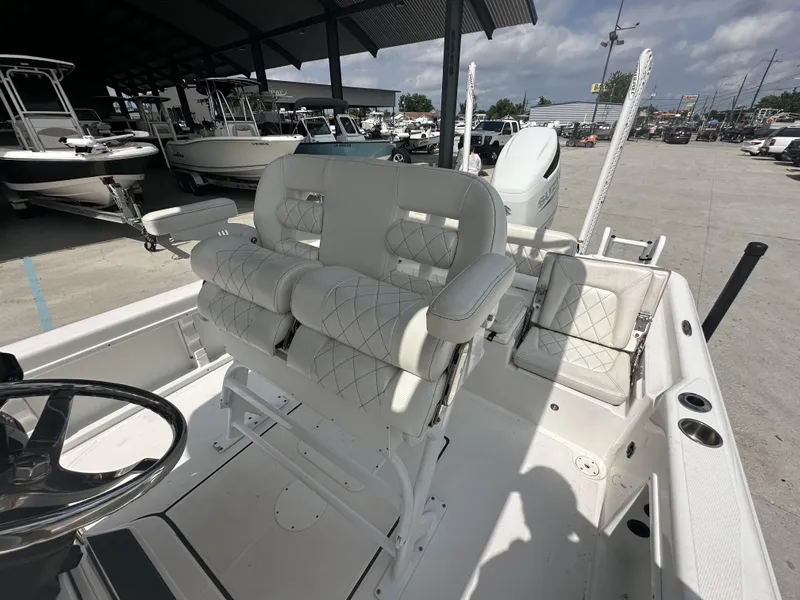 Slide: The Image of 2022 Blue Wave 2400 PURE BAY boat interior with white cushioned seating and steering wheel. - 17