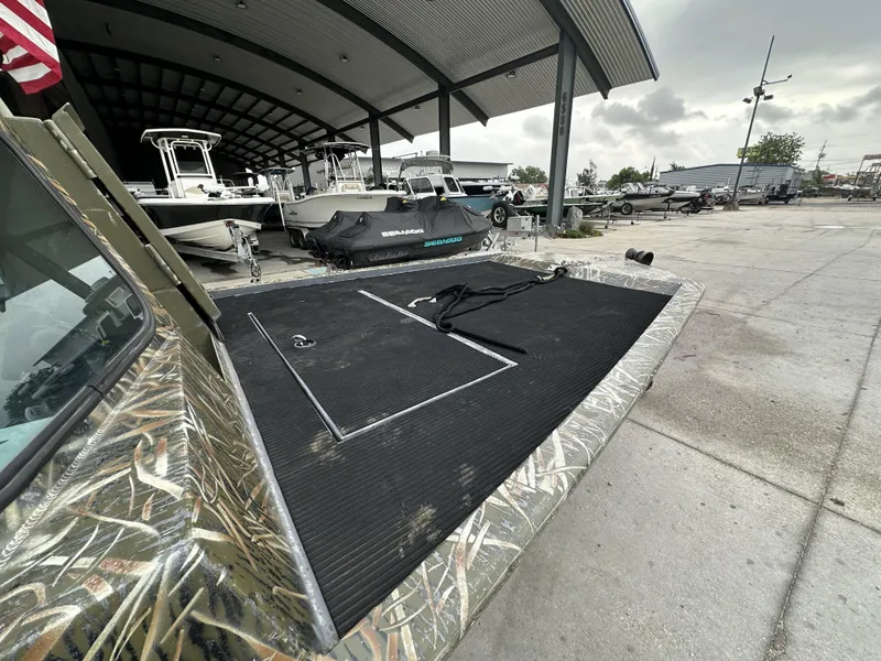 Slide: The Image of Custom 2004 model boat with camouflage design at a marina, surrounded by other boats. - 7